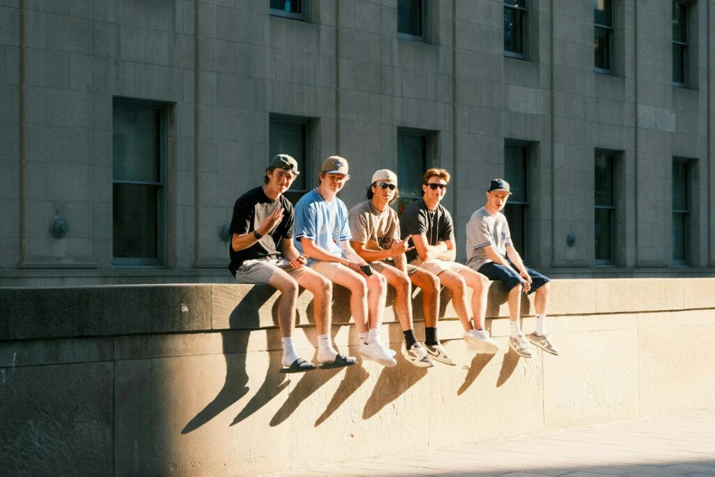 A group of people sitting on top of a cement wall