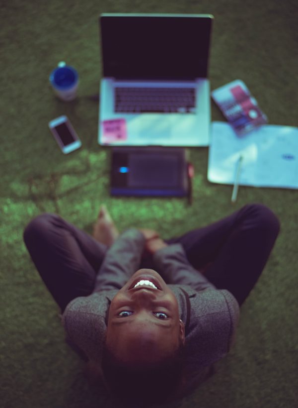 top view photo of woman sitting near MacBook Pro facing the camera